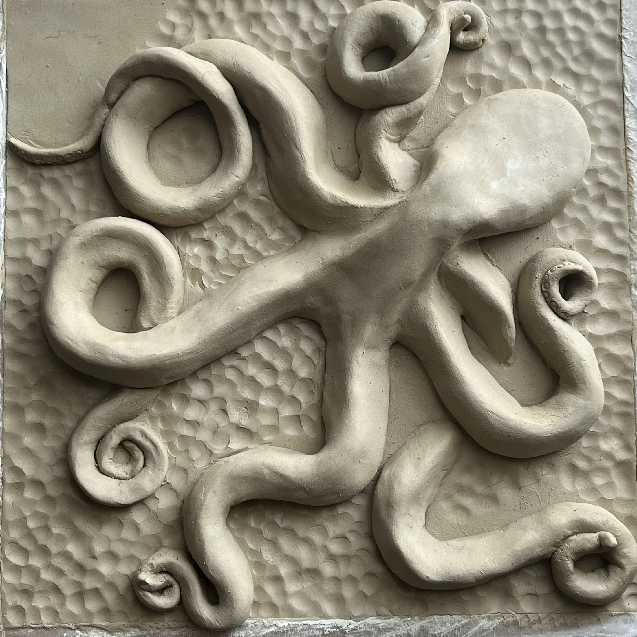 Oc, a clay sculpture with looping organic forms on a textured base